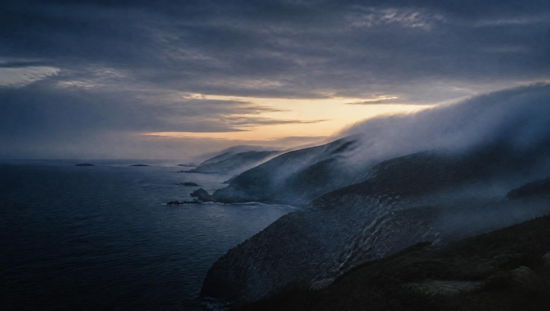 Mist moving over a coastal headland at first light